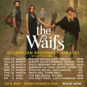 The Waifs tour poster. White and yellow writing. Photo of the band standing on a dirt road in the bush. The two female members who are sisters are holding hands in the middle of the photo. Another member is to the right holding a guitar. 